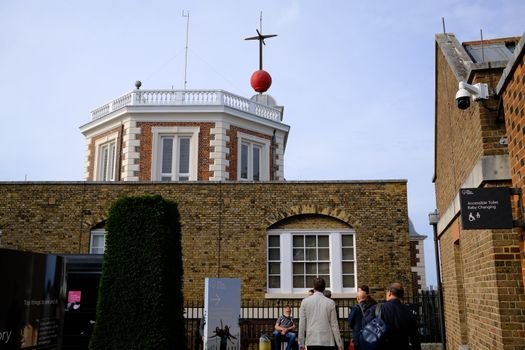 Tourists gather at the Royal Observatory in Greenwich, iconic for the Prime Meridian.